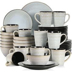 a stack of white dishes and cups with black rims