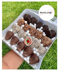 a box filled with lots of different types of chocolates on top of green grass