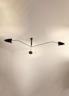 two lamps are hanging from the ceiling in a room with white walls and flooring