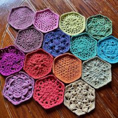 crocheted hexagons are arranged on the floor in many different colors