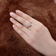 a woman's hand with a diamond ring on her finger