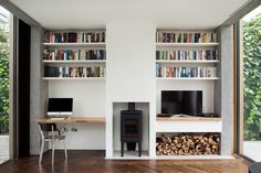 a living room filled with furniture and bookshelves next to a firewood pile