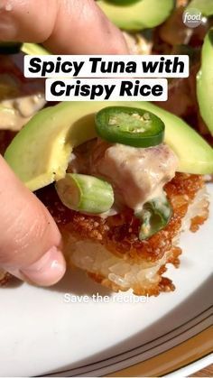 a person picking up an avocado on top of a piece of bread with the words spicy tuna with crispy rice