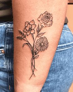 a woman's arm with flowers and leaves on the left side of her body