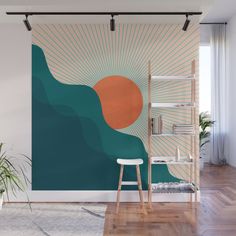 a room with a wall mural that has an orange circle on it and blue waves in the background