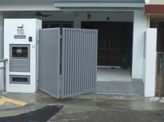 an open metal gate in front of a building with a parking meter next to it