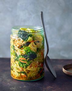 a glass jar filled with pasta and broccoli