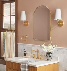 a bathroom with a sink, mirror and two lights on the wall next to it