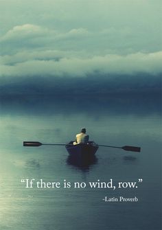 a man in a row boat on the water with dark clouds above him and behind him, there are two oars