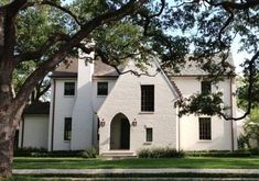 a white house with trees in front of it