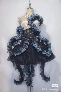 a mannequin dressed in black and blue with ruffles on the skirt