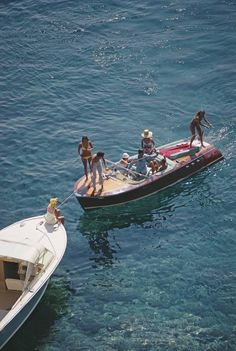 several people on a small boat in the water with one person standing on the front