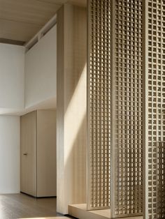 a room divider in the middle of a room with sunlight coming through it and casting shadows on the floor