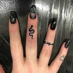 two fingers with tattoos on them, one has a snake and the other has a cross