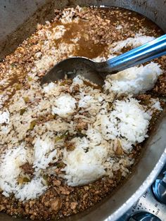 a pan filled with rice and meat on top of a stove