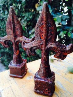 two rusted iron candlesticks sitting on top of a wooden table