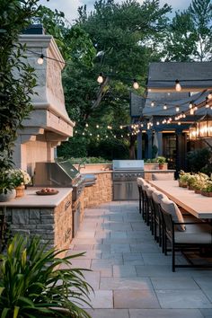 Outdoor patio with a large stone grill, wooden dining table, and string lights hanging above. Outdoor Kitchen And Spa, Barbecue Set Up Ideas, Outdoor Kitchen And Patio Ideas, Outdoor Kitchen And Dining Area, Entertainment Area Ideas Indoor, Outdoor Kitchen With Fireplace, Backyard For Entertaining, Small Outdoor Kitchen Design, Small Outdoor Kitchen