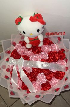 a hello kitty strawberry cake with roses in the shape of a heart and bow on top