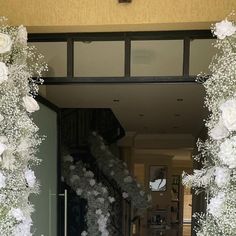 an entrance to a house decorated with white flowers