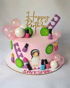 a pink birthday cake with decorations on it