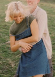 a man and woman hugging each other in a field