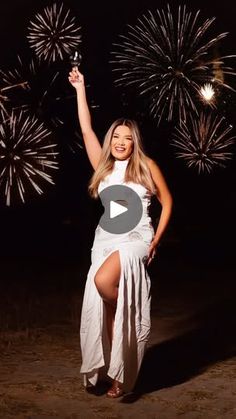 a woman in a white dress is holding fireworks