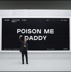 a man standing in front of a sign that says poison me daddy on it