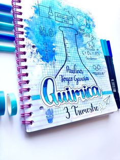 a spiral notebook with writing on it next to some markers and pens in front of it