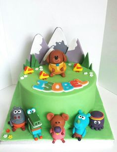 there is a cake decorated with cartoon characters on the top and green frosting in the middle