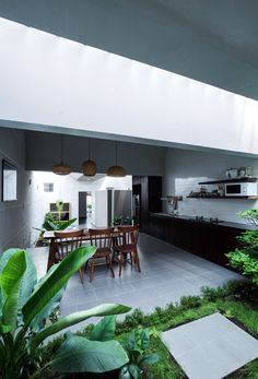 an open kitchen and dining area with green plants