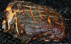 a piece of meat sitting on top of a black table covered in brown and white stuff