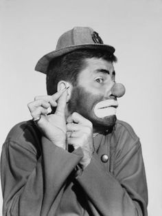 a man with a fake nose and hat on his head is holding something in front of his face