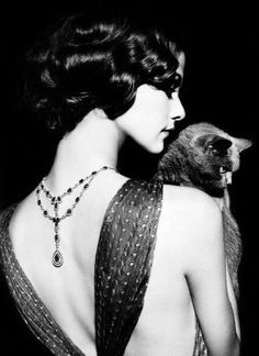 a woman in a dress holding a small animal