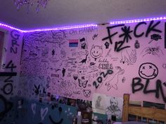 the wall is covered in graffiti and has purple lights above it, along with other items