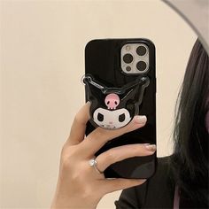 a woman holding up a phone case with a pig on it