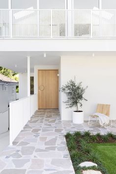 a white house with a wooden door and balcony