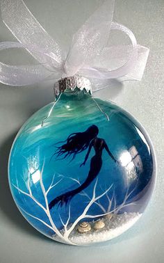 a glass ornament with a mermaid painted on it