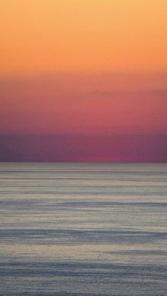 the sun is setting over the ocean and there are two boats out in the water