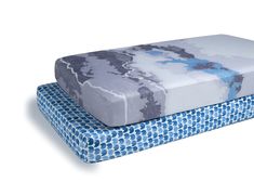 two blue and white mattresses sitting next to each other on top of each other