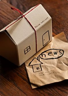 a brown paper bag sitting on top of a wooden table next to a white box