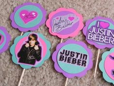 the cupcakes are decorated with stickers on them and have pictures of justin bieber