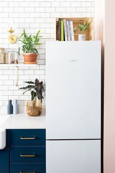 a white refrigerator freezer sitting inside of a kitchen next to a blue counter top