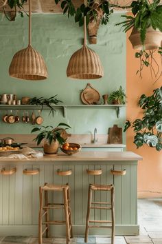 a kitchen with green walls and wooden stools in front of an island counter topped with potted plants