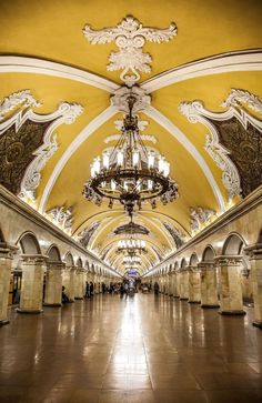 the inside of a train station with chandelier and marble pillars on either side