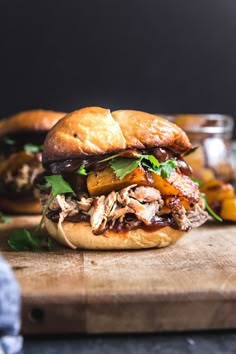 two pulled pork sandwiches on a cutting board