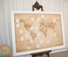 an old world map is displayed on a easel in front of a white curtain