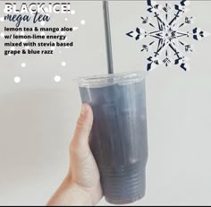 a hand holding a plastic cup with a straw in it and snowflake on the top