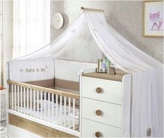 a baby crib with a white canopy over it's head and drawers in the foreground