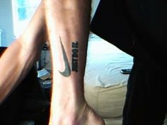 a man with a nike tattoo on his leg