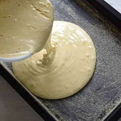 a person pouring batter on top of a doughnut